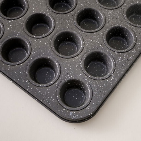  یک عدد قالب کیک کوچک 24 حفره‌ای با پوشش تیره و نقطه‌های سفید 